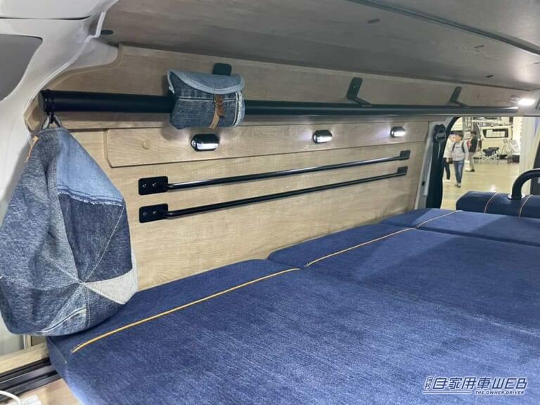 車内の壁面にあるバー。|「車のシートだよね?」「すげぇ…デニム地だ」汚してナンボ、経年劣化を楽しみたい。真っ青なシートが魅力のキャンピングカー。