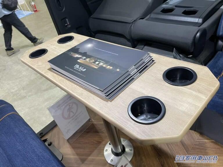 ドリンクホルダー付きのテーブル。|「車のシートだよね?」「すげぇ…デニム地だ」汚してナンボ、経年劣化を楽しみたい。真っ青なシートが魅力のキャンピングカー。