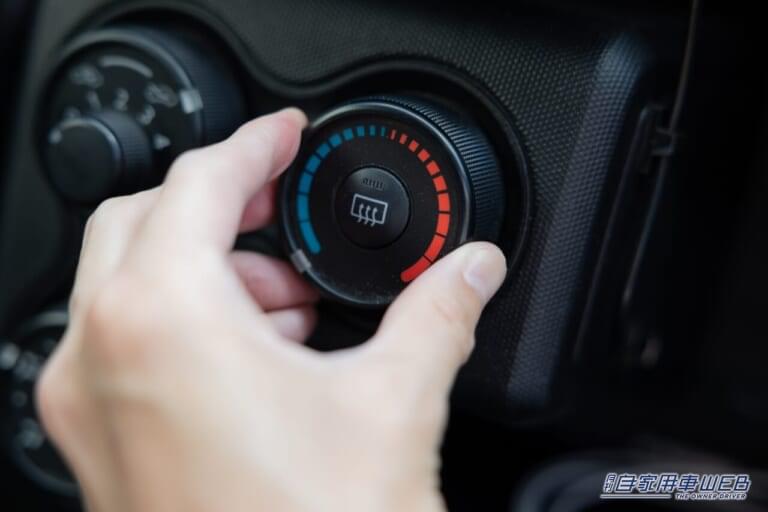カーエアコンの温度設定スイッチに触る人の写真|夏場のカーエアコン、燃費ヨシ&車内環境ヨシのベストな設定はコレ!