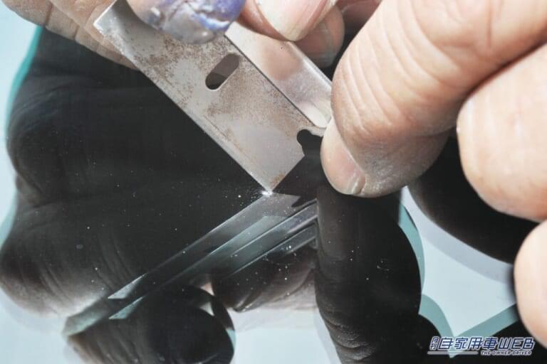 キットに付属するカミソリで破片を取り除く。|「あちゃ〜飛び石…。テンション下がるなぁ」「えっ自分で修理できるの?」フロントガラスのヒビ簡単補修キットを実践!気になる仕上がりは…