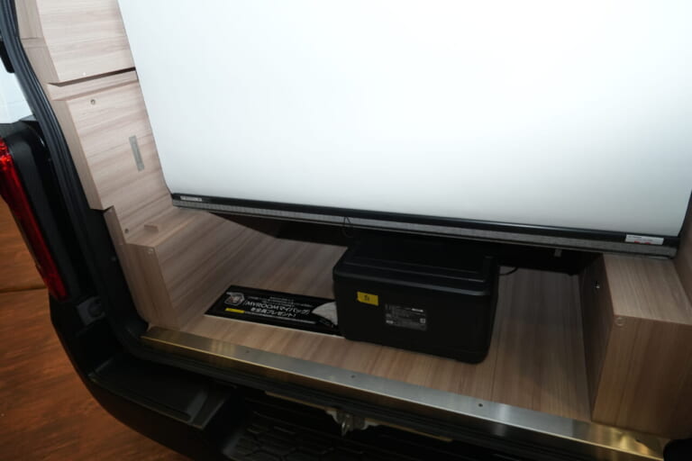 日産 キャラバン MYROOMの車内、展示車はオプションのロールスクリーンを搭載。