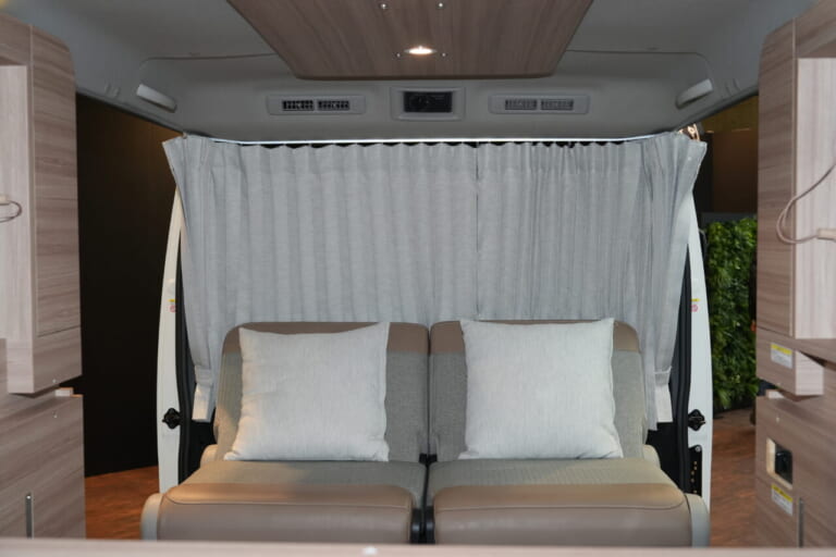 日産 キャラバン MYROOMの車内、展示車はオプションのロールスクリーンを搭載。