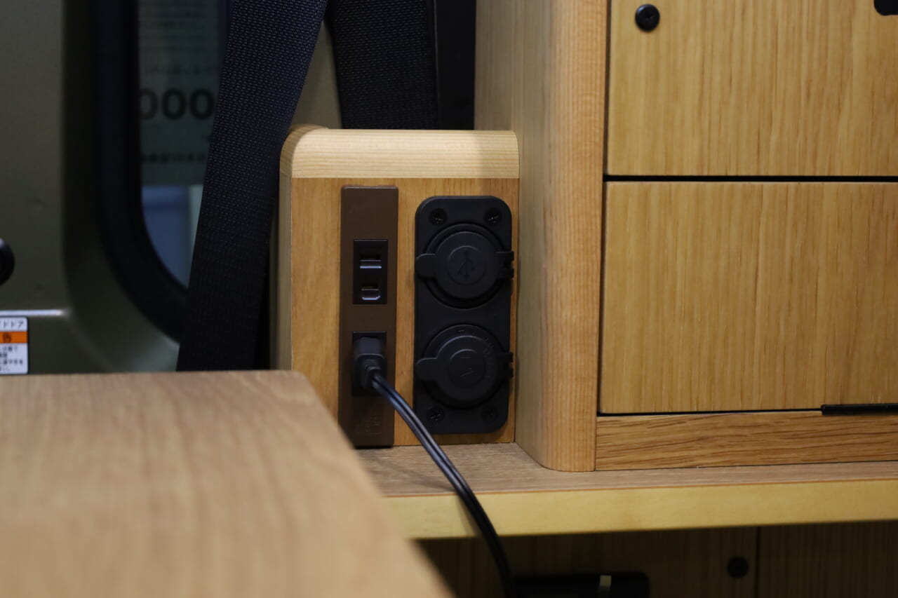 100VコンセントとUSBポートは12Vクーラーがある棚の下部に設置。就寝時も利用しやすい。｜「軽なのに…“最強”!?」無骨カッコいい、安っぽくない！軽キャンパーに見えない存在感。