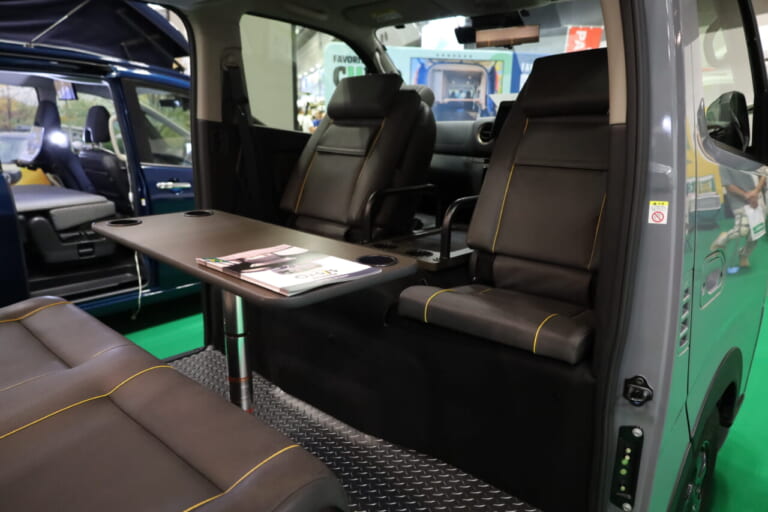 オプションのシートバックを利用すれば運転席・助手席の背面を背もたれにしたシートができ、対面対座のフロントダイネットスペースが展開できる。｜「激シブじゃん…」「無骨さもグッとくる」遊び心を刺激する多彩なギミックが魅力的。3段ベッドが魅力的なキャンピングカー。