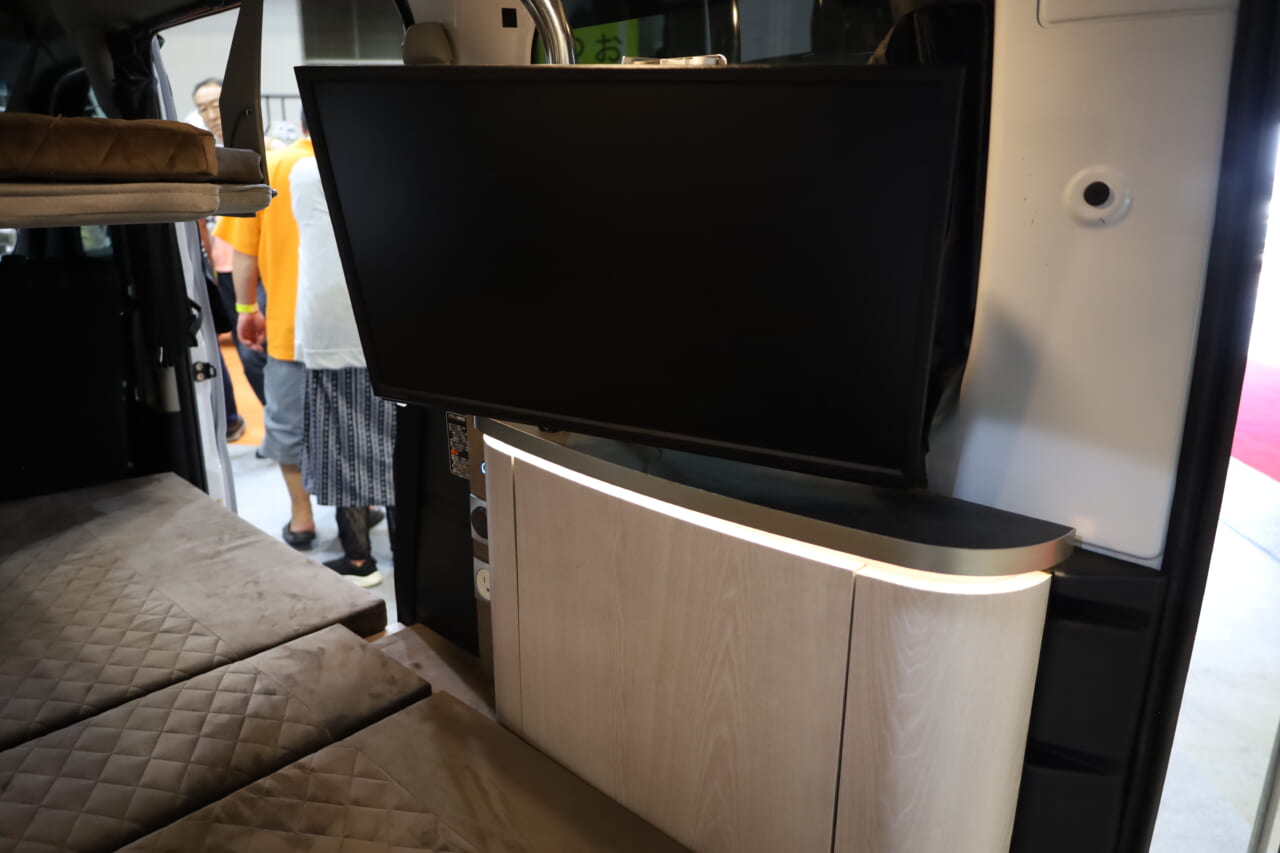 オプションのテレビはオーバーヘッドコンソールに回転式のステーで設置。室内のどこからでも見やすい角度に調整できる。｜斬新「軽自動車」だけどホテルみたいな車内。しかも2段ベッド付き4名乗車も可、優雅な大人の軽キャンパー。