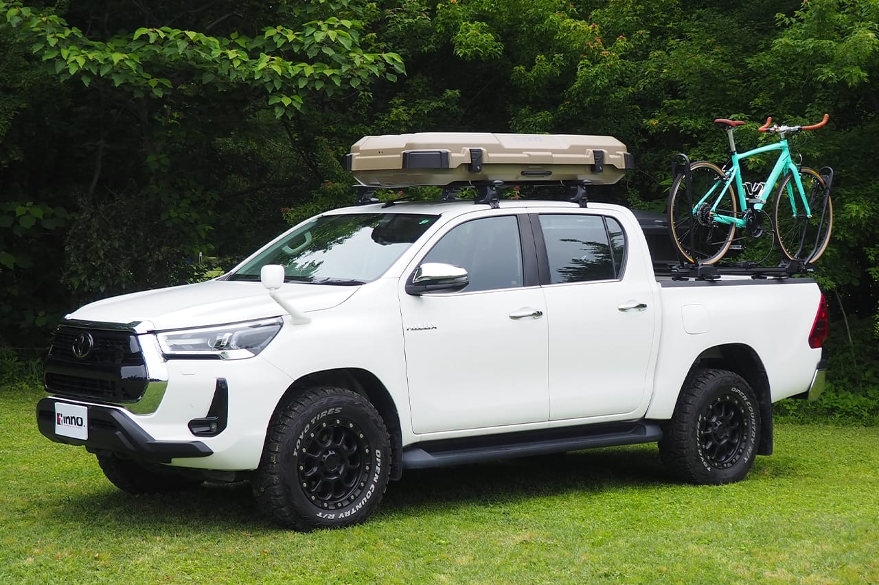 トヨタのハイラックスに、INNO ルーフギアケース720の新色、マットベージュを搭載｜「コレよく見るけど、何が入ってるの？」屋根の上の平べったいボックスの正体。「ああ、そうやって使うんだ？めっちゃ便利やん！」