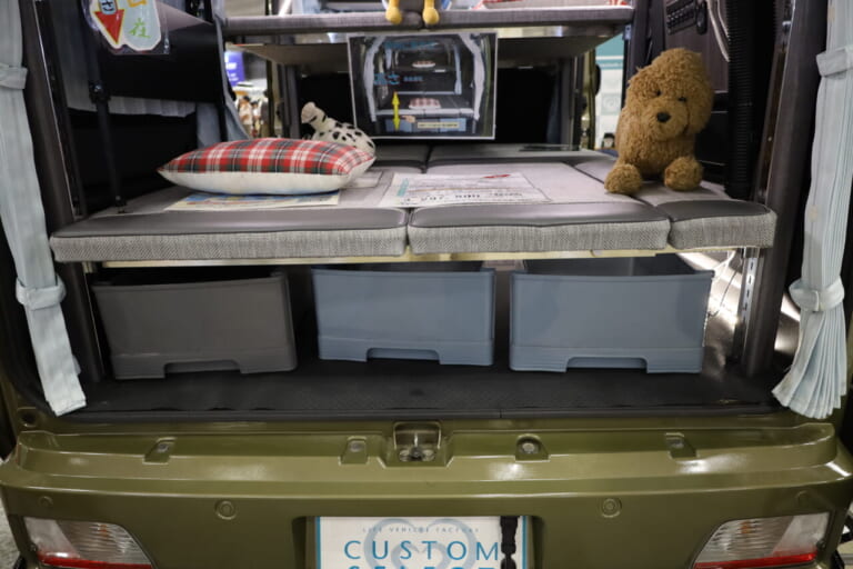 高さ調整可能な下段ベッド下は大容量の収納スペース。キャンプや釣りなど荷物の多い車中泊で活躍。長尺モノもしっかり収まる。｜「えっ 軽自動車だよ？」「一体どんな仕掛けが…」4人が横になって寝られる、魔法の軽キャンパー。贅沢な就寝スペースが魅力的。