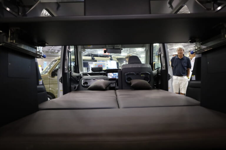 スライド式のテーブルは室内の中程まで引き出すことが可能。車内がお座敷スタイルのお茶の間になり、雨が降ってもボードゲームなどを興じて親子水入らずのひとときが楽しめる。日帰り小旅行も気軽に出かけることができる1台だ。｜「えぇーっ！ これヤバッ」ぱっと見シンプル。だけど魅力的な機能が搭載。車中泊を快適にするトールボディのキャンピングカー。
