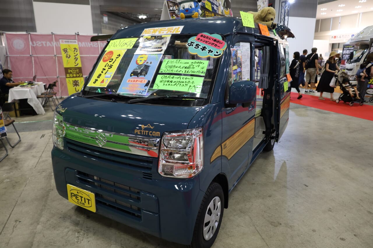 東京キャンピングカーショー2025で展示されていたぷちキャンWAGのベース車はスズキ•エブリイJOINターボ。木目調サイドデカールがバンコン感を引き上げる。|「えぇーっ 流石にスゴイ」「本当に軽自動車ですか?」バンライファーにぶっ刺さる!まさかの天然木が胸を打つ、あれもこれも詰まった軽キャンパー。