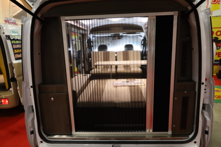 リヤゲートにアコーディオンカーテンタイプの網戸とスクリーンドアを装備。虫の侵入を気にせず開放的な室内空間でくつろげる。|「これは凄いぞ…」ヤバい軽キャンパーがデビューニューモデルは、めっちゃ嬉しい機能付き。高級感のある落ち着いた、開放的な室内空間は圧巻。