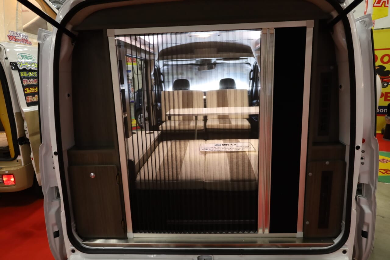 リヤゲートにアコーディオンカーテンタイプの網戸とスクリーンドアを装備。虫の侵入を気にせず開放的な室内空間でくつろげる。｜「これは凄いぞ…」ヤバい軽キャンパーがデビュー。ニューモデルは、めっちゃ嬉しい機能付き。高級感のある落ち着いた、開放的な室内空間は圧巻。