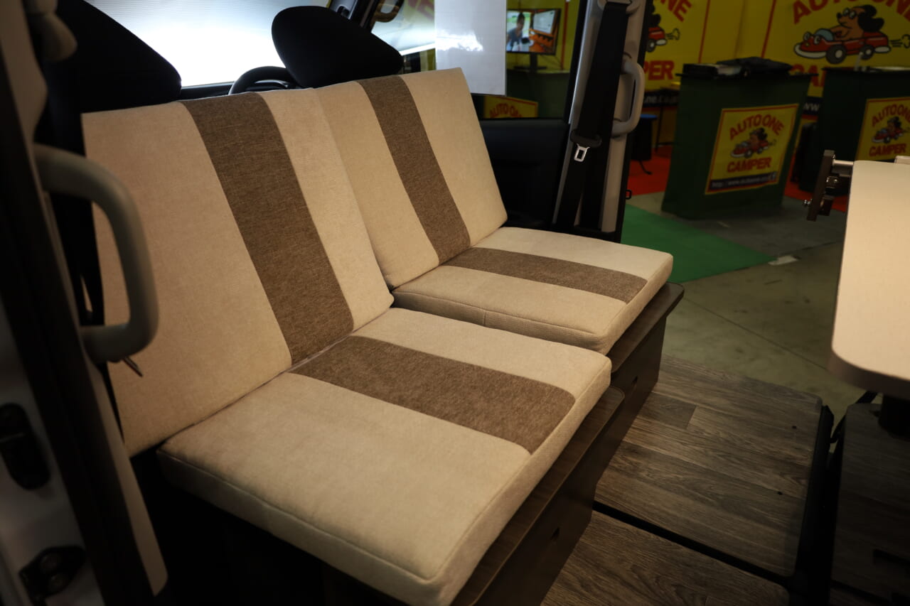 ダイネットのフロント側のシートは運転席•助手席の背もたれを利用して展開。｜「これは凄いぞ…」ヤバい軽キャンパーがデビュー。ニューモデルは、めっちゃ嬉しい機能付き。高級感のある落ち着いた、開放的な室内空間は圧巻。