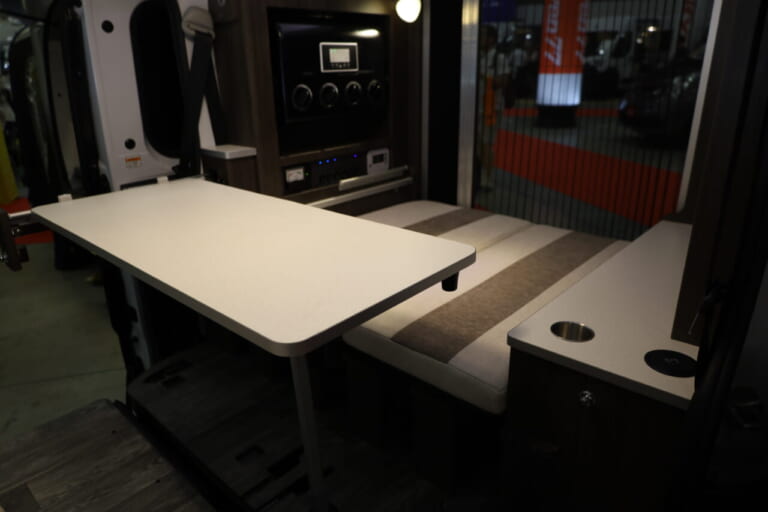 ダイネット展開時のリヤ側のシート。小さなお子さんなら2人でも余裕のスペースで、キャビネットの天板はテーブルとしても活用できる。|「これは凄いぞ…」ヤバい軽キャンパーがデビューニューモデルは、めっちゃ嬉しい機能付き。高級感のある落ち着いた、開放的な室内空間は圧巻。