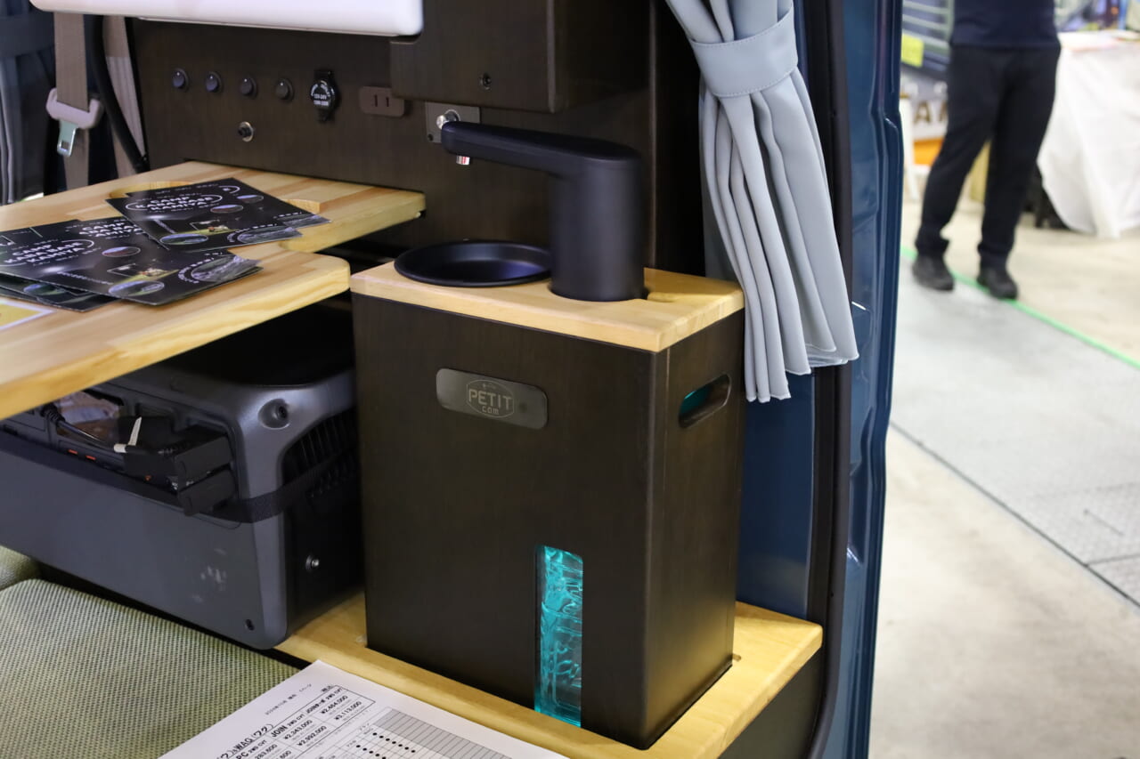 2Lペットボトルの給•排水タンクを搭載する小型ギャレー。本体ごと車外に持ち出して使うこともできる。|「えぇーっ 流石にスゴイ」「本当に軽自動車ですか?」バンライファーにぶっ刺さる!まさかの天然木が胸を打つ、あれもこれも詰まった軽キャンパー。