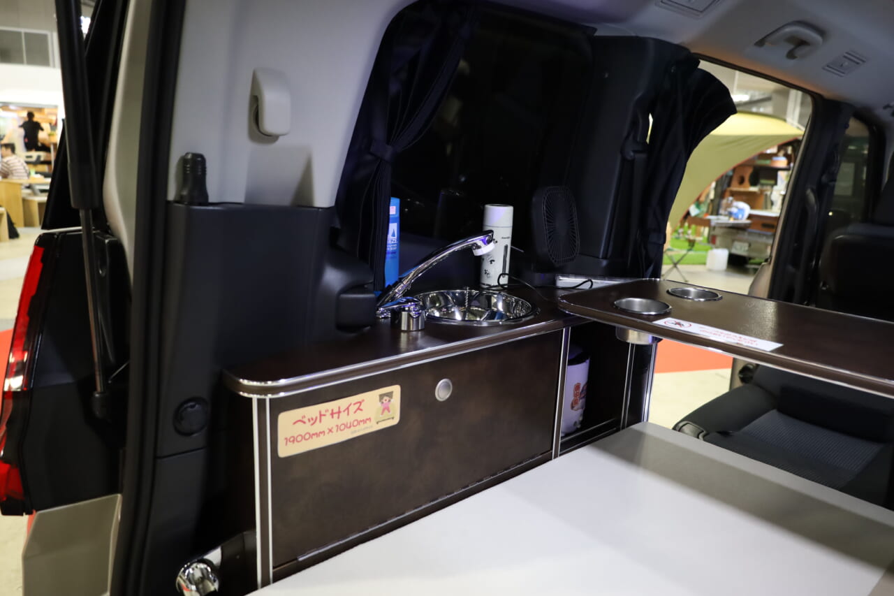 高級感のあるシャワーフォーセット付きシンク。給•排水タンク(各5L)はベッド台座のリアゲート側に格納し、積み下ろしが楽に行える。|トヨタの“超すごい”ミニバンが「もはや部屋」みたいな車内に。好きな人にブッ刺さる、充実装備の特別仕様車は「理想的」すぎてグッと来る。