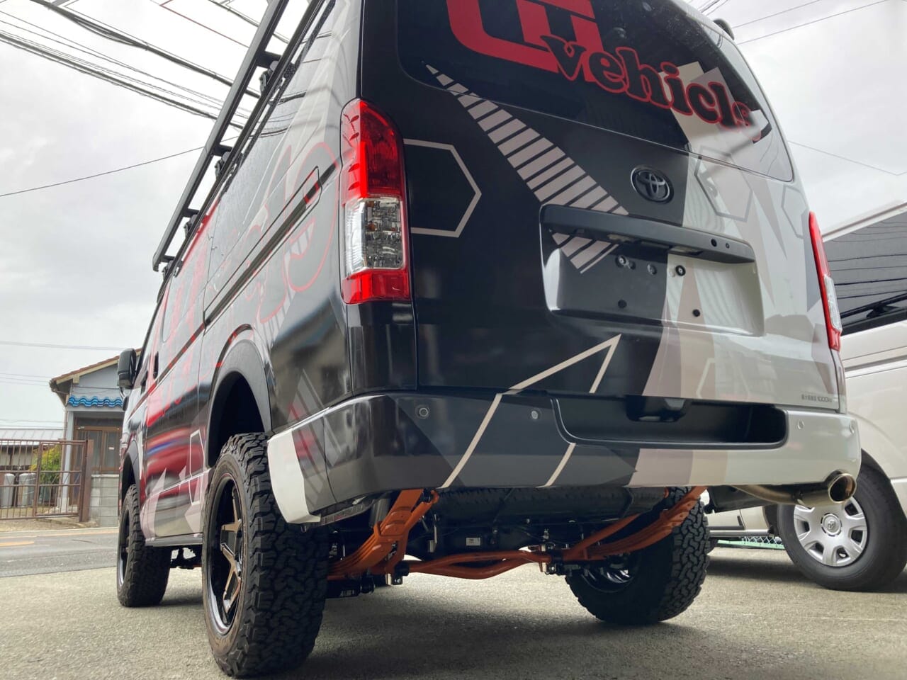 ハイエースの乗り心地改善『足回りパーツ4点セット』の内容は、フロント強化スタビライザー、リア追加スタビライザー、コンフォートショックアブソーバー、オプティマリーフの4つ。ちらりと見えるオレンジのパーツが車好きの心を弾ませる。｜「これは卑怯…好きに決まってる」趣味全開な大人にブッ刺さる、ワイルドなデザイン。釣り人が釣られる超絶特化型キャンピングカー。