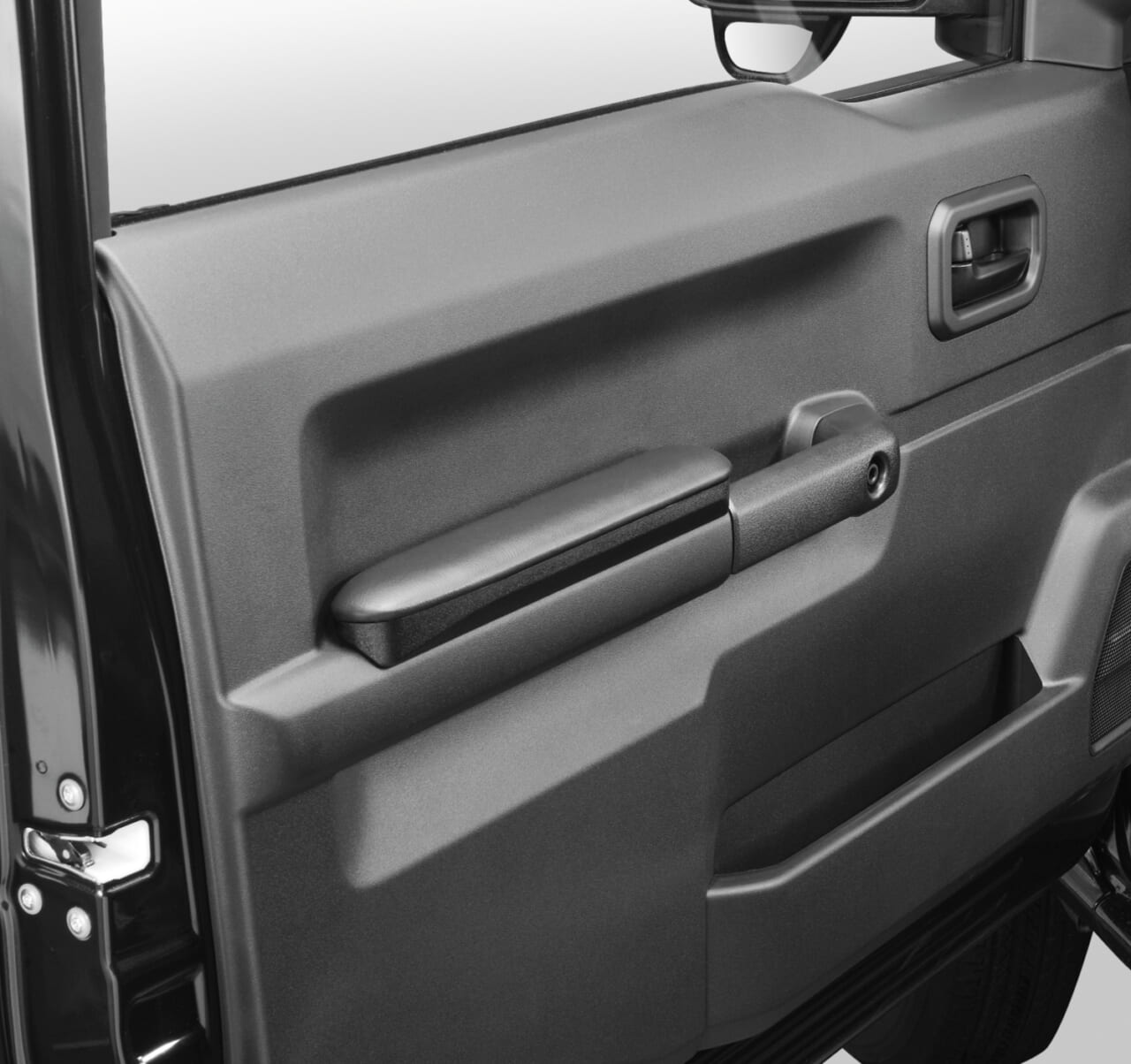 カーメイトのドアアームレストを装着した状態のジムニーのドア(助手席側)|「これは知らなかった…」ドライバーだけでなく同乗者にも恩恵。クルマのドアグリップの意外な活用方法。