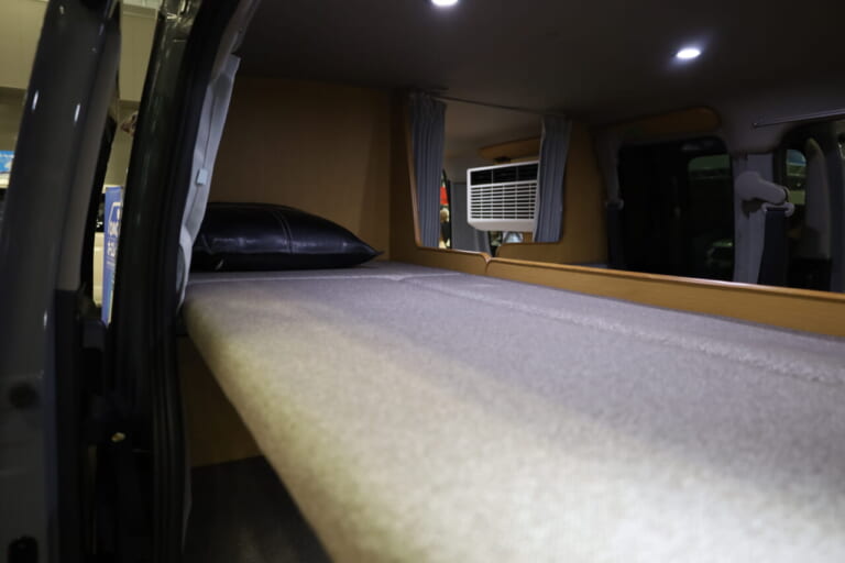上段ベッドのサイズは幅650mm×1850mm。ソロや二人旅なら荷物置き場としても活用できそうだ。｜「おいおい、これは住めちゃうぞ」クルマの中に電子レンジや冷蔵庫、キッチンまで装備。もはや1Kの部屋みたいで便利に使えそう。