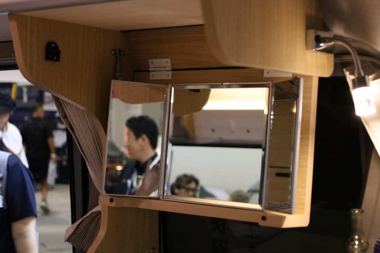 展示車はシンクの上部にオプションの三面鏡を装備。フリップダウン式で走行時は収納すればガタつくこともない。｜「軽とは思えない」チープさ排除でブッ刺さる、まるで走るタイニーハウス。普通に手の届く価格帯が嬉しい軽キャンパー。