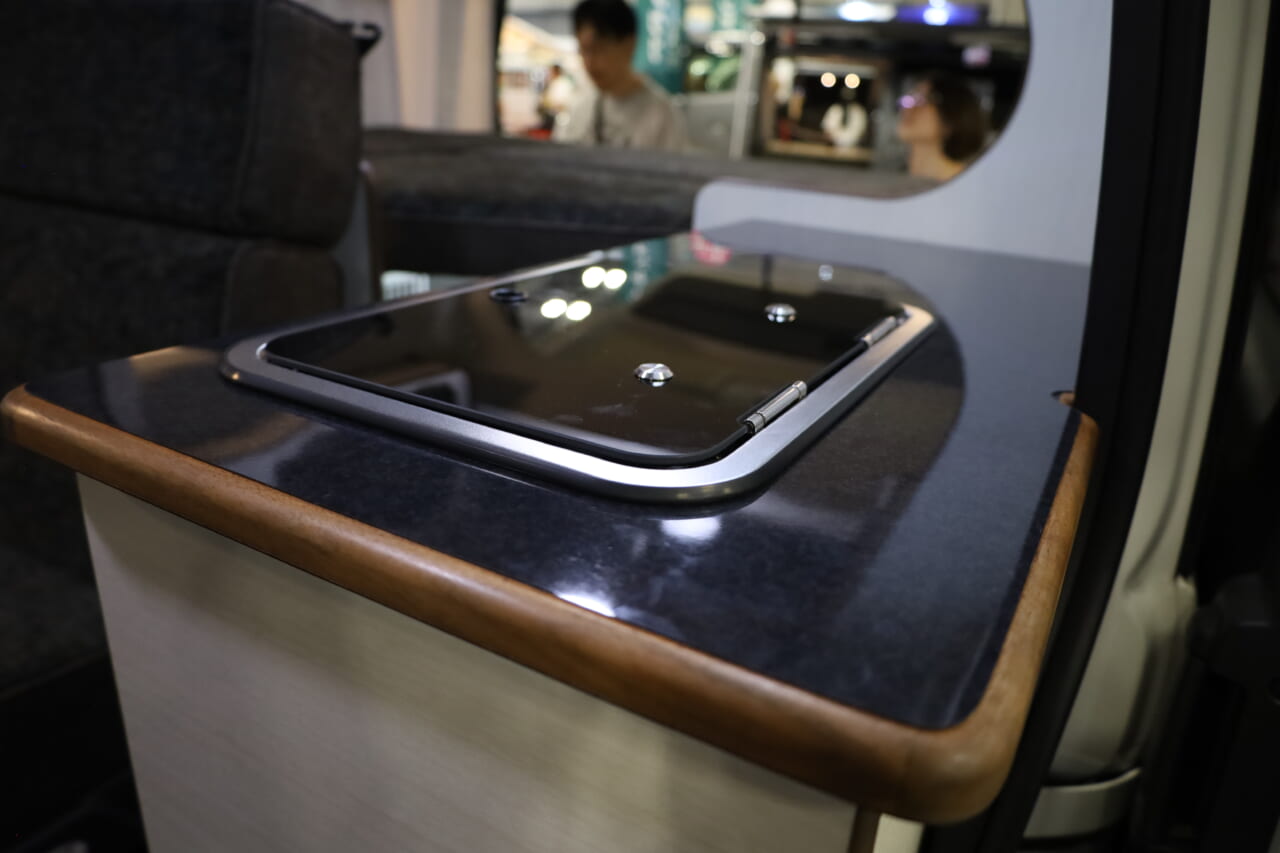 シンクは美しい強化ガラスでフタができ、未使用時は生活感を隠すことができる。キャビネットはオプションで電子レンジもビルトインも可能だ。|トヨタ車「衝撃の広さに感服」サイズ選びの新基準、ありそうでなかった珠玉の一台。経済的にクルマ旅。駐車場にも困らない。