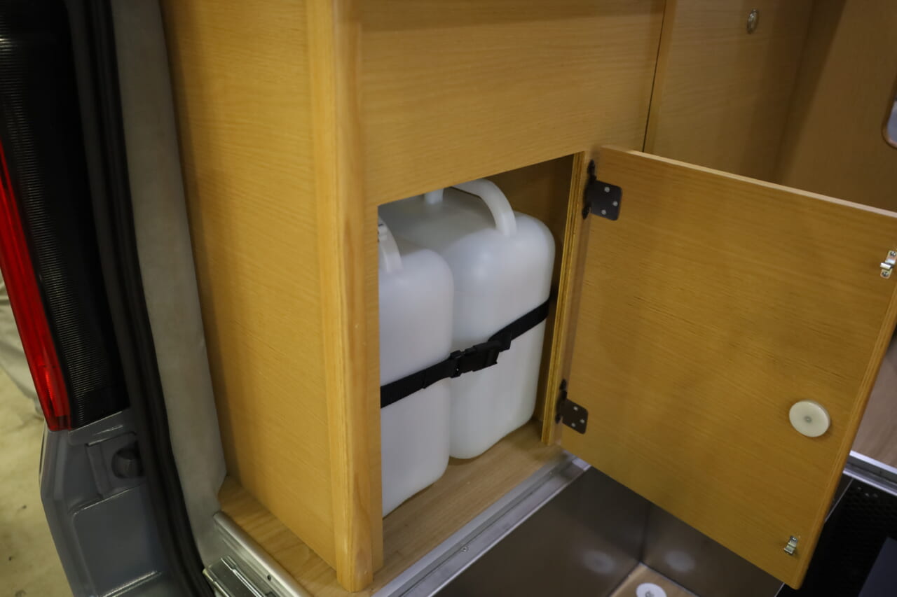 シンク下には給•排水タンクを格納。最後部にあり積み下ろしがしやすい。｜「おいおい、これは住めちゃうぞ」クルマの中に電子レンジや冷蔵庫、キッチンまで装備。もはや1Kの部屋みたいで便利に使えそう。