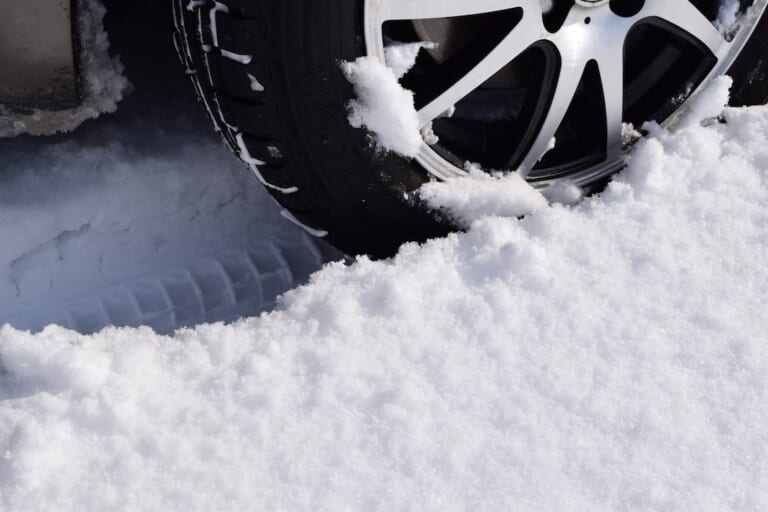 雪道と自動車のタイヤ。｜「マジで持ってて良かった…」雪で立ち往生…たった1つのキットが命運を分ける。クルマに積んでおけばめちゃくちゃ安心できるアイテムを紹介
