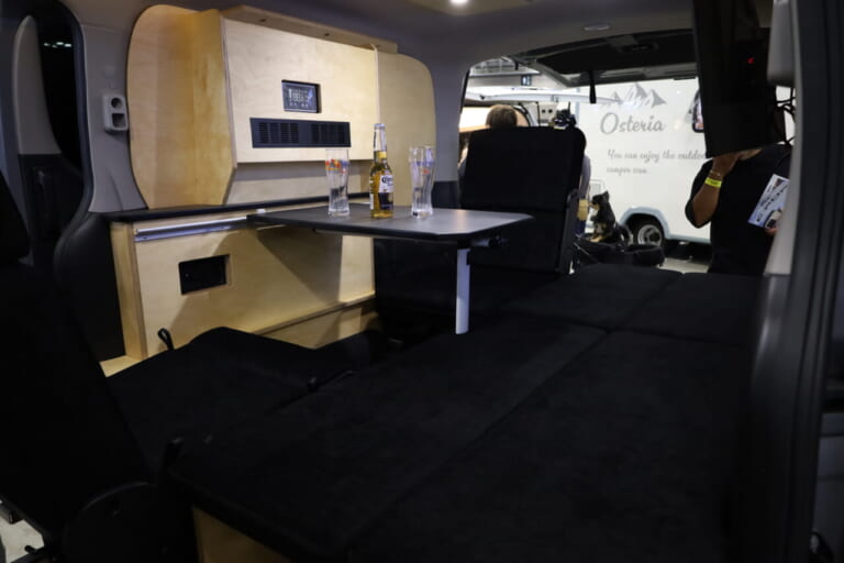 テーブルを外し、ハイバックシートをフラットにすれば就寝定員2名のフルフラットベッドが展開できる。｜「そんなのアリ…？」「これは住めちゃう車」ソファみたいなシートが素敵。キッチン・冷蔵庫・電子レンジ装備。
