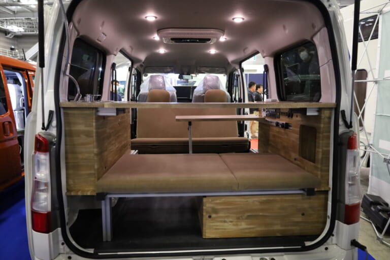 対面ダイネットモードの室内。天井にはLED照明が設置され、車中泊の夜もシーンに合わせて快適にすごせる。就寝時はセカンドシートとリヤ側のベンチを連結することで全長約1800mm×幅約1200mmのフルフラットベッドになり、大人2人でもゆったり眠れる。｜はっきり言って「ここに住めます」トヨタ車の室内は「まさにワンルーム」絶妙なサイズ感がグッドだね。キッチン・シャワー付き。