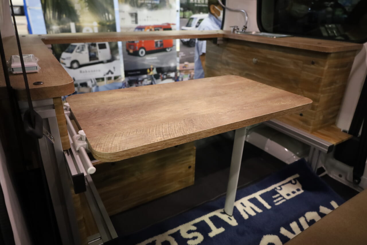 対面ダイネットの中心となるヴィンテージ調のセンターテーブル。3Dアルミフレーム構造に設置し、安定性も高い。｜はっきり言って「ここに住めます」トヨタ車の室内は「まさにワンルーム」絶妙なサイズ感がグッドだね。キッチン・シャワー付き。