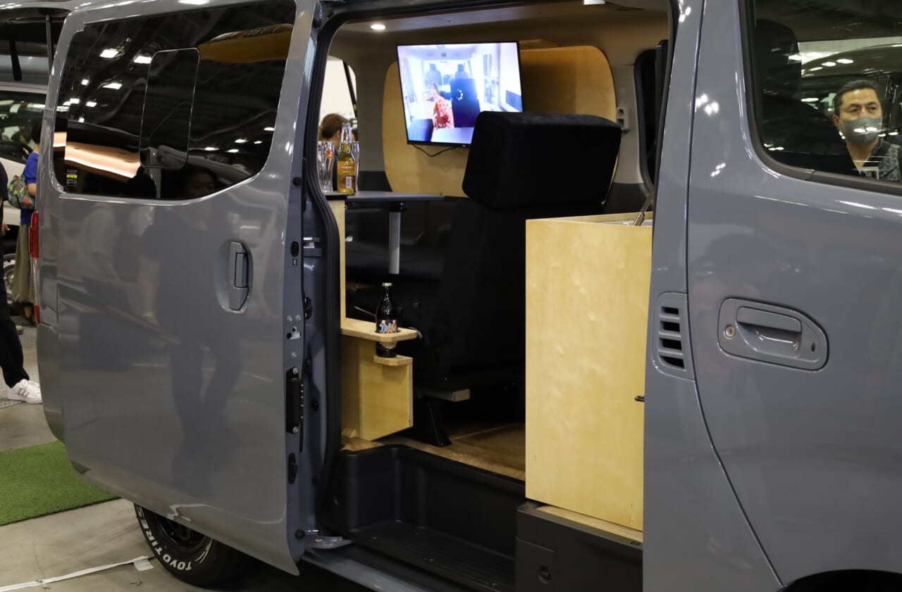 リヤのハイバックシートのドリンクホルダーもホワイトバーチのインテリアで統一。シートを前向きにした走行モードでも使いやすく、細部まで優れた機能と上質なデザインの融合が図られている。｜「そんなのアリ…？」「これは住めちゃう車」ソファみたいなシートが素敵。キッチン・冷蔵庫・電子レンジ装備。