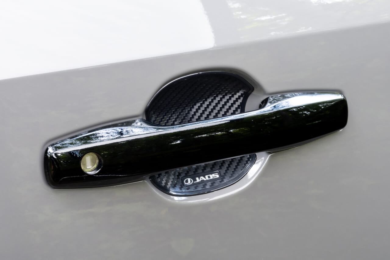 RAV4 アドベンチャーに装着された、JAOS ドアハンドルプロテクター（カーボン調）｜「こんなに雰囲気が変わるんだ…」トヨタ 新型RAV4のカスタマイズ車両がド迫力すぎてヤバい！ タフでワイルドなSUVに大変身！