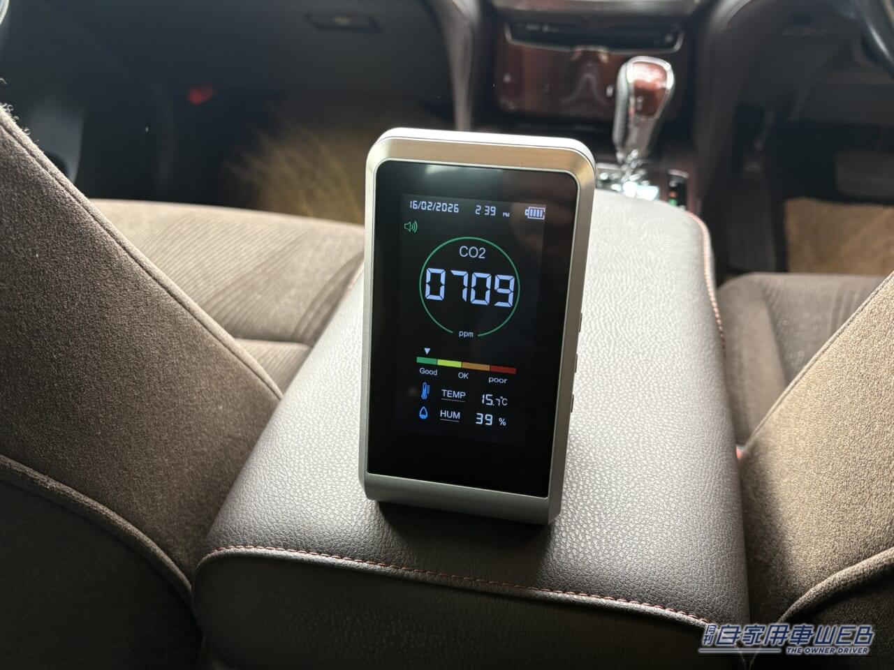 210系クラウンのアームレストに置かれた二酸化炭素濃度計。内気循環での計測開始時値|「そのエアコン設定 実はヤバい…」愛車の花粉対策。知らないと車内が地獄に。2026年春のピーク直前対応マニュアル