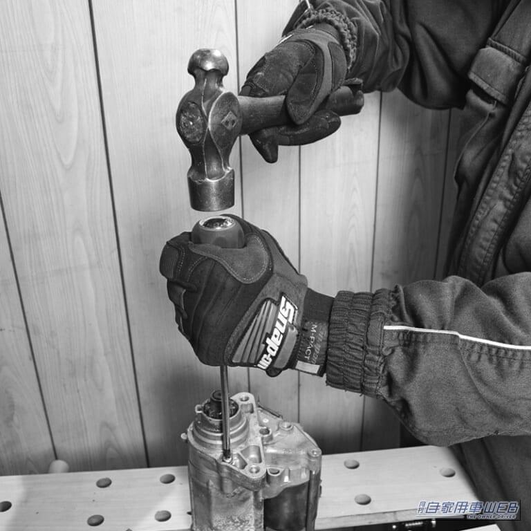 貫通ドライバーのグリップの後端をハンマーで叩く画像｜「これマジでスゴい…」固着したネジが瞬時にゆるむ驚きの裏ワザ。誰でも実践可能なテクニックを紹介