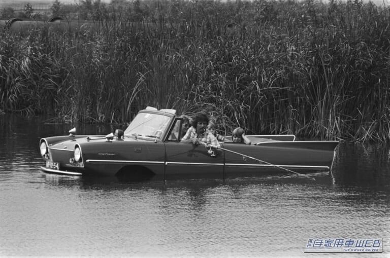 水上に浮かぶアンフィカーに乗って、男性が釣りを楽しんでいる画像|「これはスゴいわ…」日本のガレージでとんでもない激レア車両が眠っていた! ピカピカにしてオークション出品すると、スゴい展開に…!