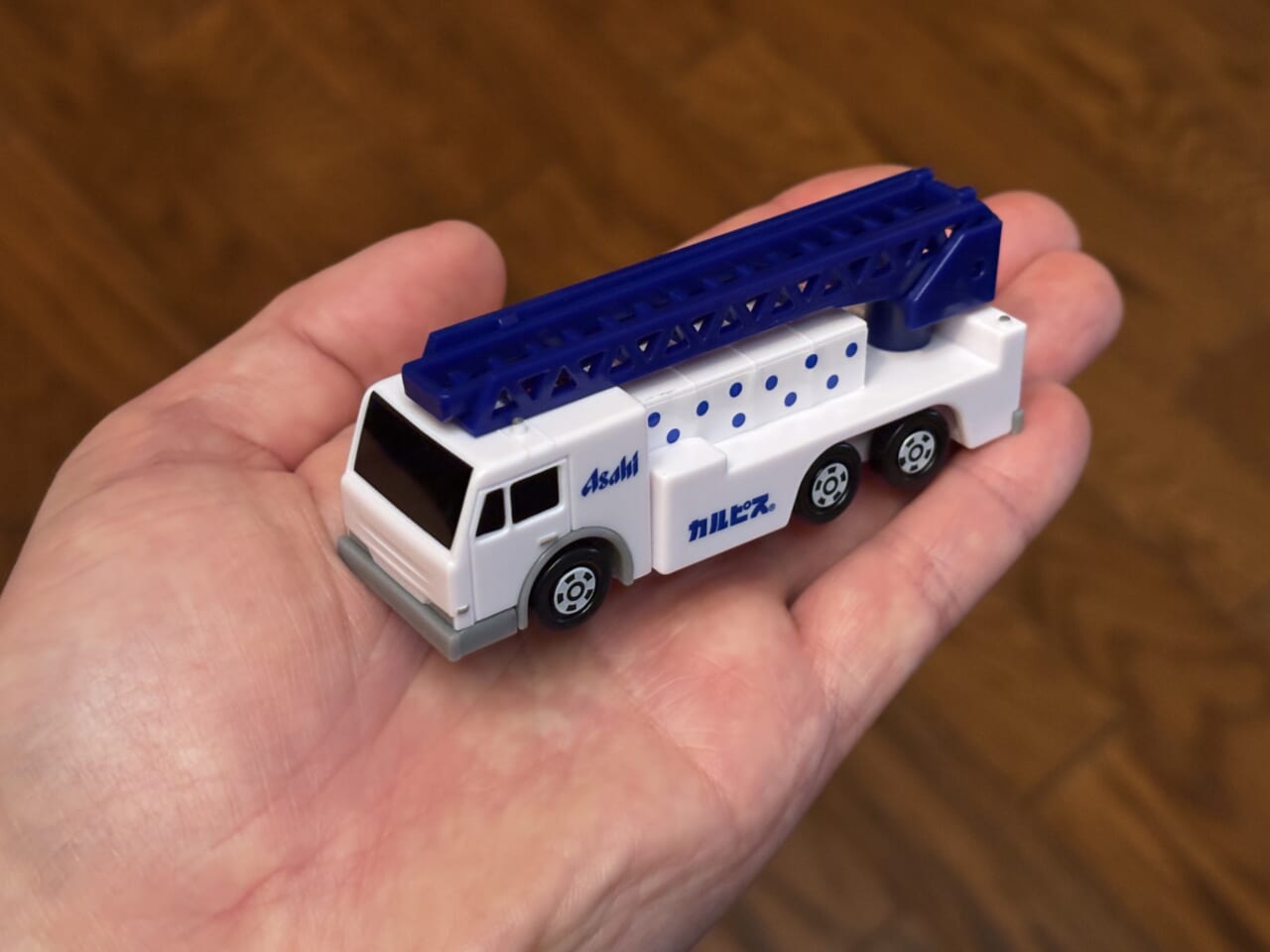 セブンイレブンとアサヒ飲料のキャンペーントミカのカルピス レスキューカーを手のひらに乗せた画像｜「えっ…コレ全部集めたい…」限定トミカがその場でもらえるキャンペーンをセブンイレブンで実施中！ 早速1台ゲット！