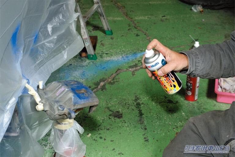 青い耐熱塗料をブレーキキャリパーに噴き付けている|「えっ…見慣れた愛車が劇変したわ」「まるで純正のような仕上がり…」さりげないけど効果抜群のドレスアップテクを紹介