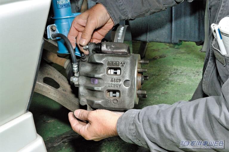 スバル車の左前のブレーキキャリパーのスライドピンボルトを緩めている｜「えっ…見慣れた愛車が劇変したわ」「まるで純正のような仕上がり…」さりげないけど効果抜群のドレスアップテクを紹介