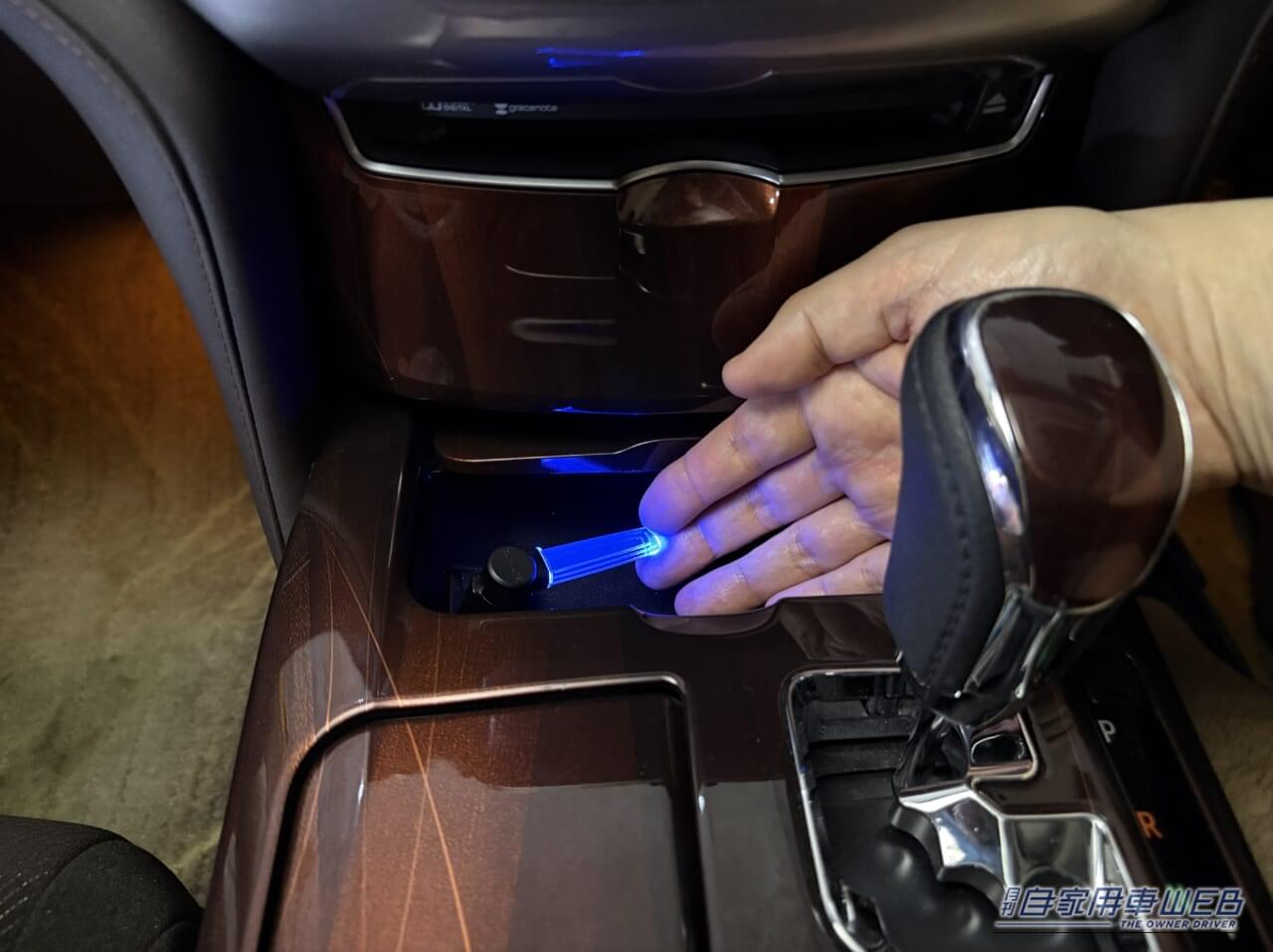 カーメイトのクリスタルランプ USBタイプ ブルーLED(CZ406)を、210系クラウンの小物入れ内のUSBに装着して点灯させ、手を添えた画像|「使わないなんてもったいない…」見落としがちな車内装備活用術。「コレめっちゃいいわ…」カー用品で見つけたグッズを購入。実際にクルマに装着!