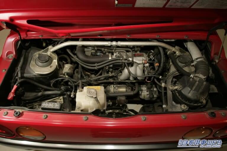 赤いボディのマツダ オートザム AZ-1のエンジンルーム｜バブルが生んだ34年前の軽スーパーカー。唯一無二のドアを記憶している人も多いはず。マツダが生んだ偉大な経スポーツ「オートザム・AZ-1」を掘り下げる