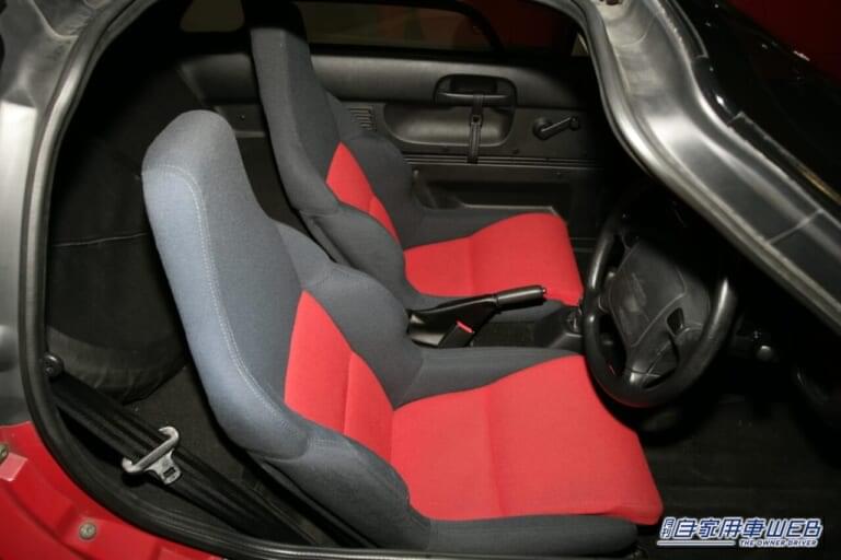 赤いボディのマツダ オートザム AZ-1の車内を運転席側から撮影した写真。|バブルが生んだ34年前の軽スーパーカー。唯一無二のドアを記憶している人も多いはず。マツダが生んだ偉大な経スポーツ「オートザム・AZ-1」を掘り下げる