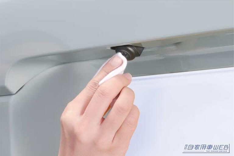 自動車のバックモニター用のカメラレンズにコーティング剤を塗布している画像｜「雨で後ろが全然見えない…」バックモニターの邪魔をする水滴。超簡単施工で映像がクリアに！ 車種問わず対応の［カーメイト・C108 エクスクリア カメラコーティング］