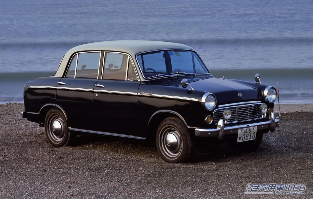 日産の、初代 ダットサン・ブルーバード（310型）が砂浜に停車している写真｜「国産車のデザインを根底から変えた…」時代を先取ったスーパーソニックラインが印象的な60年前の日産車。海外でも評価が高かった大ヒットモデル［ダットサン・ブルーバード（510型）］