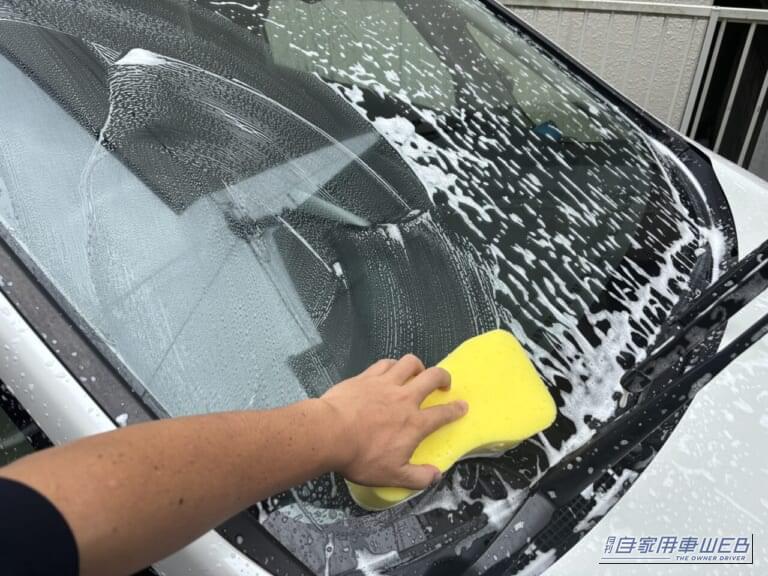 ホンダ・フリードのフロントガラスを洗っている写真｜「2000円でお釣りがくる」ドンキ情熱価格の電源不要［らく泡フォームガン］はホントに使える？ 実際に使用してその実力を愛車フリードの洗車でチェック！