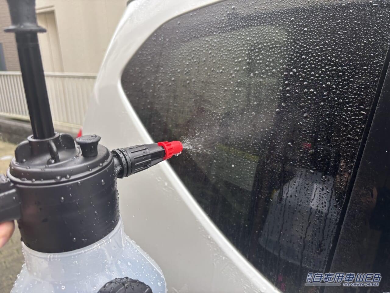ドン・キホーテの情熱価格「らく泡フォームガン」の水ノズルで、自動車の窓に水を吹き付けている写真｜「2000円でお釣りがくる」ドンキ情熱価格の電源不要［らく泡フォームガン］はホントに使える？ 実際に使用してその実力を愛車フリードの洗車でチェック！