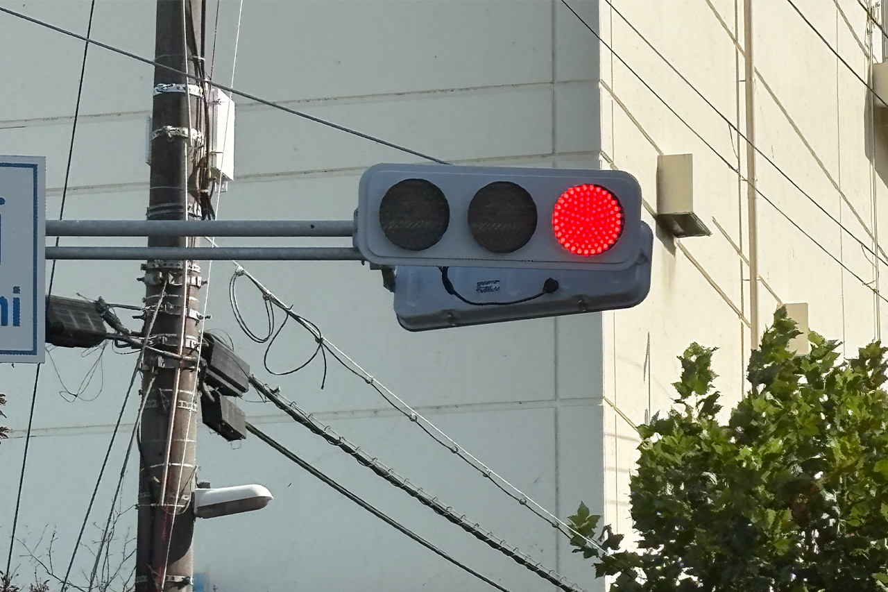 赤が点灯している、LEDタイプの信号機｜信号機「黄色は真ん中、赤と青はどっちだっけ…」“色の並び”は全国共通。実はこの順番にもちゃんと理由があった！ 意外と知らない信号の常識