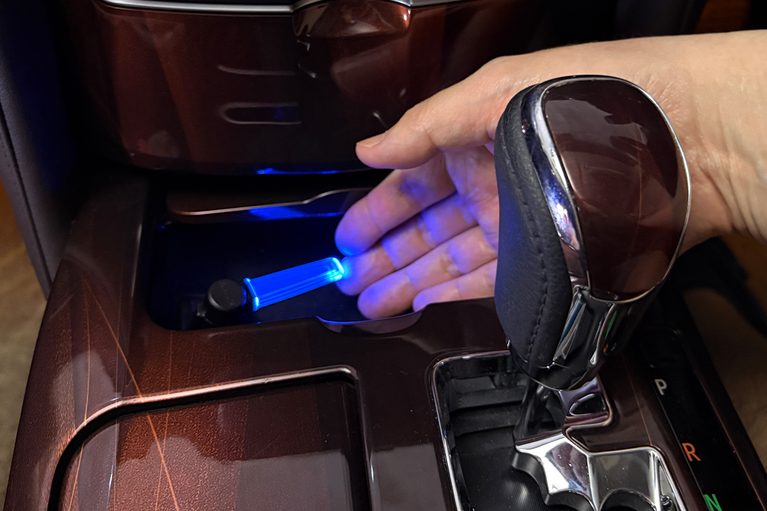カーメイトのクリスタルランプ USBタイプ ブルーLED（CZ406）を、210系クラウンの小物入れ内のUSBに装着して点灯させ、手を添えた画像｜「たった1000円で愛車をイメチェン！」幅広い車種で使えるドレスアップグッズを購入！ 簡単取付けなのに効果は抜群。実用性も高い［カーメイト・クリスタルランプ USBタイプ ブルーLED（CZ406）］をレビュー！