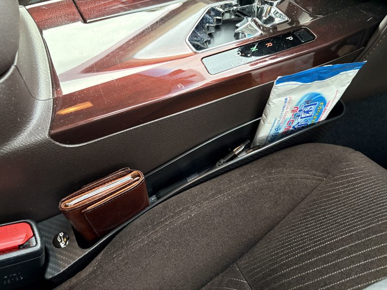 トヨタの210系クラウンの運転席とセンターコンソールの隙間に小物入れをセットした状態の写真|「めっちゃイライラする…」物を落としやすいシートの隙間。このデッドスペースにぴったりハマる小物入れを購入! 簡単設置のカーグッズを紹介!