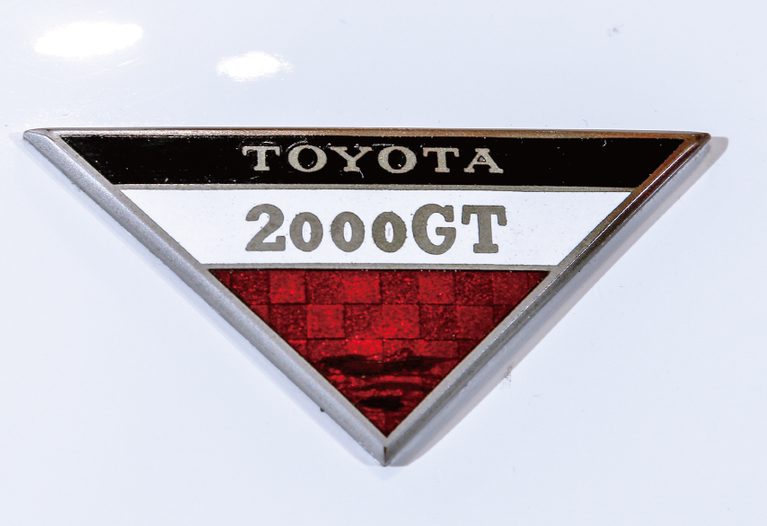 トヨタ2000GTに付けられた逆三角形のバッジ（赤）｜「似て非なるもの…。59年前に登場した“コロナ”の皮を被った狼」レーシングスペック・ヤマハDOHCを搭載した【トヨタ1600GT】の凄さ